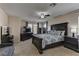 The main bedroom features ample natural light, dark furniture, and a ceiling fan at 6457 Lovett Canyon St, Las Vegas, NV 89148
