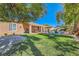 A spacious backyard with a refreshing pool, patio seating, lush lawn, and mature trees providing shade at 6527 Lokai Ave, Las Vegas, NV 89130