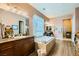 Primary bathroom showcasing a soaking tub, dual vanities, and dark wood cabinets at 6527 Lokai Ave, Las Vegas, NV 89130
