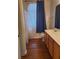 Bathroom with dark floors, single sink vanity, and window with blue curtain at 700 Carnegie St # 2013, Henderson, NV 89052