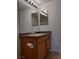 Bathroom vanity features wood cabinets, a white sink, and multiple mirrors at 7255 W Sunset Rd # 2093, Las Vegas, NV 89113