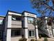 View of the condo complex with two tone brown and white exterior, balcony and stairs at 7255 W Sunset Rd # 2093, Las Vegas, NV 89113