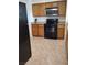 A well-equipped kitchen features wooden cabinets, black appliances, and tile flooring at 7255 W Sunset Rd # 2093, Las Vegas, NV 89113
