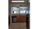 Galley kitchen with stainless steel dishwasher, wood cabinets, and granite countertops overlooks the living room at 7255 W Sunset Rd # 2093, Las Vegas, NV 89113