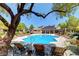A communal pool is surrounded by lounge chairs, landscaping, and a clubhouse at 7255 W Sunset Rd # 2093, Las Vegas, NV 89113