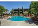 Community pool with lounge chairs and an umbrella table for relaxation at 7255 W Sunset Rd # 2093, Las Vegas, NV 89113