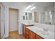 Luxurious bathroom featuring dual sinks, wood cabinets, and a glass-enclosed shower at 7624 Molfetta St, Las Vegas, NV 89149