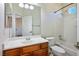 Bathroom with wood vanity, large mirror, shower-tub combo, and tile flooring at 7624 Molfetta St, Las Vegas, NV 89149