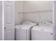Bright laundry room equipped with a washer, dryer, and overhead storage at 7624 Molfetta St, Las Vegas, NV 89149