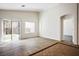 Spacious living room with wood-style flooring, sliding glass door, and abundant natural light at 7624 Molfetta St, Las Vegas, NV 89149