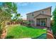 A lush backyard with a well-manicured lawn, mature trees, and a covered patio area at 7837 Hamilton Pool Dr, Las Vegas, NV 89113