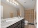 Bathroom with double vanity, large mirror, and shower with decorative curtain at 7837 Hamilton Pool Dr, Las Vegas, NV 89113