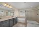 Bright bathroom with double sink vanity, soaking tub, and walk-in shower with glass door at 7837 Hamilton Pool Dr, Las Vegas, NV 89113