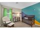 Cozy Bedroom featuring a comfortable rocking chair and a playful accent wall at 7837 Hamilton Pool Dr, Las Vegas, NV 89113