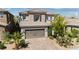 Two-story home with a tile roof, brick driveway, desert landscaping, and an attached two-car garage at 7837 Hamilton Pool Dr, Las Vegas, NV 89113