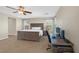 A spacious main bedroom with a large bed, ceiling fan, dedicated office, and carpet flooring at 7837 Hamilton Pool Dr, Las Vegas, NV 89113