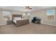 A well-lit main bedroom with a ceiling fan, large bed, and dedicated office space at 7837 Hamilton Pool Dr, Las Vegas, NV 89113