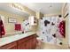 Classic bathroom features a granite countertop, complemented by a shower-tub combo and vanity mirror at 7913 Rushmore Ave, Las Vegas, NV 89131