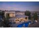 An aerial shot showcases the house with a pool, fire features, outdoor seating, and desert-style landscaping at 80 Glade Hollow Dr, Las Vegas, NV 89135