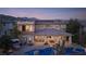 An aerial view of the backyard featuring a pool, outdoor kitchen, and modern landscaping against a mountain backdrop at 80 Glade Hollow Dr, Las Vegas, NV 89135