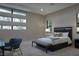 Neutral bedroom with a modern bed, gray bench and lots of natural light at 80 Glade Hollow Dr, Las Vegas, NV 89135