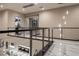 Open landing with modern railing, marble floors, contemporary lighting, and views to the first floor at 80 Glade Hollow Dr, Las Vegas, NV 89135