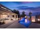 Stunning backyard pool with fire features and covered patio at dusk at 80 Glade Hollow Dr, Las Vegas, NV 89135