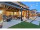 Outdoor patio space with chairs, string lights, and lush lawn area for entertaining at 8115 Cowboy Springs St, North Las Vegas, NV 89085