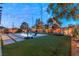 Serene backyard with a sparkling pool, lush lawn, and ambient string lights for relaxing evenings at 8115 Cowboy Springs St, North Las Vegas, NV 89085