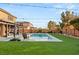 Landscaped backyard oasis featuring a refreshing pool, green turf, and privacy fencing, ideal for relaxation and outdoor enjoyment at 8115 Cowboy Springs St, North Las Vegas, NV 89085