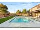 This backyard features an inground pool, ample grass, and patio seating area at 8115 Cowboy Springs St, North Las Vegas, NV 89085