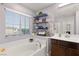 Well-lit bathroom with a tub, vanity, and organized shelving for toiletries and decor at 8115 Cowboy Springs St, North Las Vegas, NV 89085