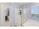 Bright bathroom showcasing a glass-enclosed shower, tub, and tile flooring at 8115 Cowboy Springs St, North Las Vegas, NV 89085