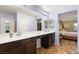 Elegant bathroom featuring dual sinks, dark cabinetry, and an adjoining bedroom at 8115 Cowboy Springs St, North Las Vegas, NV 89085