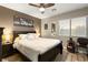 This cozy bedroom features a bed, a nightstand with lamp and a lovely window at 8115 Cowboy Springs St, North Las Vegas, NV 89085