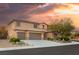 Two-story home with a three-car garage, desert landscaping and dramatic clouds behind the house at 8115 Cowboy Springs St, North Las Vegas, NV 89085