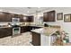 Well-equipped kitchen with granite countertops, stainless steel appliances, and a cozy breakfast bar at 8115 Cowboy Springs St, North Las Vegas, NV 89085
