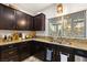 Close up on kitchen with gorgeous dark cabinets, stone countertops, and stainless steel appliances at 8115 Cowboy Springs St, North Las Vegas, NV 89085