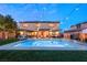 Inviting backyard pool with an outdoor seating area, pergola, string lights, and lush greenery at twilight at 8115 Cowboy Springs St, North Las Vegas, NV 89085