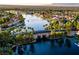 Aerial view of a Primary-planned community with a beautiful blue lake surrounded by lush trees and single-Gathering homes at 8401 Luna Bay Ln, Las Vegas, NV 89128