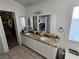 Bathroom featuring double sinks, granite countertops, tile floor, and walk-in closet at 8401 Luna Bay Ln, Las Vegas, NV 89128