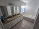 Bathroom featuring double sinks, granite countertops, and a soaking tub at 8401 Luna Bay Ln, Las Vegas, NV 89128