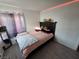 Comfortable bedroom with a full bed, wood floors and decorative pink accents at 8401 Luna Bay Ln, Las Vegas, NV 89128