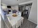 Open-concept dining area with white wood table and chairs, adjacent to the kitchen and living room at 8401 Luna Bay Ln, Las Vegas, NV 89128