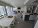 Well-lit open floor plan with a white dining table island, kitchen and adjacent living room at 8401 Luna Bay Ln, Las Vegas, NV 89128