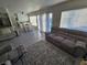Living room with a large sofa, pool view, adjacent dining area, and white kitchen at 8401 Luna Bay Ln, Las Vegas, NV 89128