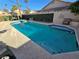 Private backyard pool featuring cool blue water, surrounded by mature landscaping and comfortable seating area at 8401 Luna Bay Ln, Las Vegas, NV 89128