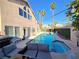 A private pool with a lounge area, complemented by swaying palm trees, offers a tranquil outdoor retreat at 8401 Luna Bay Ln, Las Vegas, NV 89128