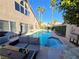 Beautiful backyard with a serene private pool, palm trees, an outdoor seating, and lush landscaping at 8401 Luna Bay Ln, Las Vegas, NV 89128
