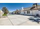 Expansive backyard with a sparkling pool, artificial grass, and a large concrete patio area at 8515 Belcastro St, Las Vegas, NV 89113